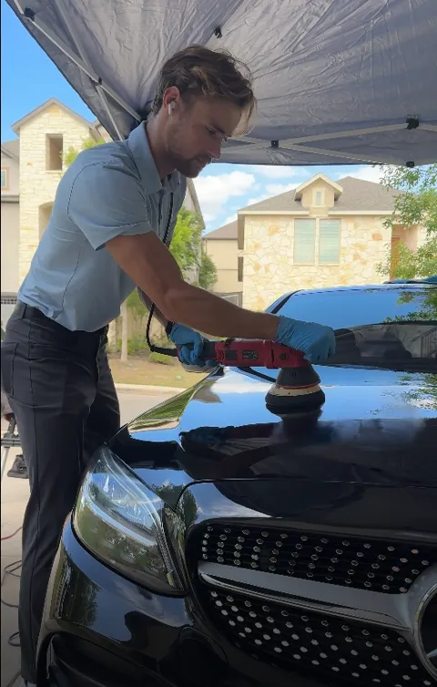 Detailer working on a vehicle hood