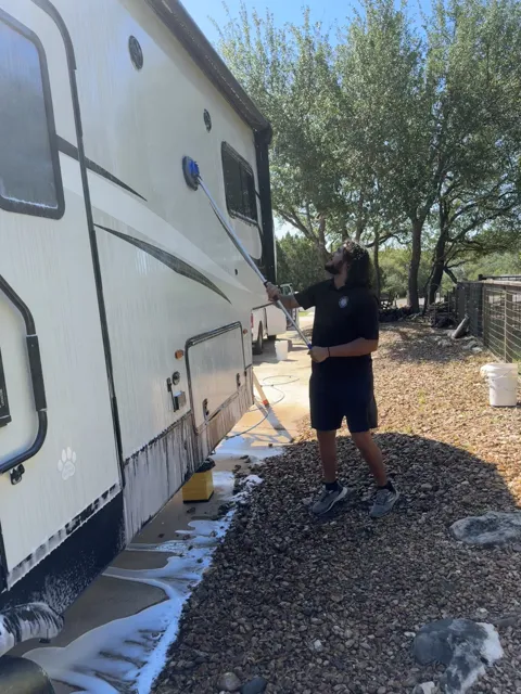 Detailer washing the side of an RV