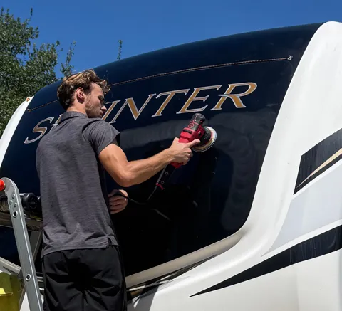 Detailer polishing an RV exterior